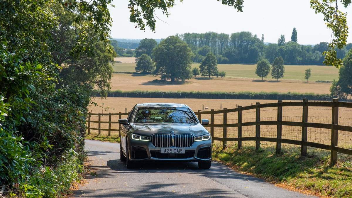 A25 Cars executive saloon on Surrey country lane with fields behind